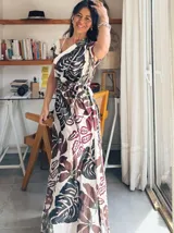 Vestido largo con estampado de hojas en tonos marrones, amarillos y verdes. Tiene escote cruzado y cinturón de la misma tela.