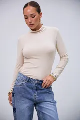 Polera básica de manga larga color beige, con cuello alto y tejido acanalado.