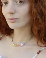 Collar corto de cuentas de colores con dije de pez de cerámica, piedras naturales y detalles en plata 925.