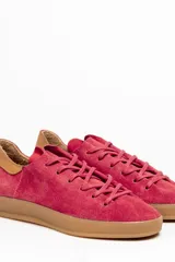 Zapatillas acordonadas de cuero vacuno color borgoña con detalle de gamuza en el talón y suela de goma color caramelo.