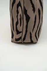 Bolso tipo tote con estampado animal print cebra en tonos marrón y negro.