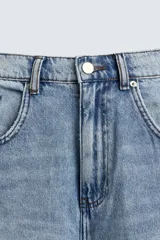 Pantalón de jean celeste con lavado gastado, corte holgado y roturas en ambas piernas.