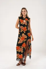 Vestido midi negro con estampado de flores naranjas y beige, espalda descubierta con tres botones en forma de flor, tajo lateral y flecos en el ruedo.