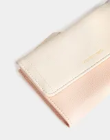 Billetera color rosa pálido con estampado de flores pequeñas, formato fichero con solapa y tag en relieve. Tiene cierre superior con puller, solapa con broche, compartimento para tarjetas y bolsillo interno con solapa.