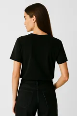 Remera color crema de algodón con cuello redondo y mangas cortas. Estampado frontal con dibujo de langosta y ostras sobre fondo de rayas verticales color naranja.