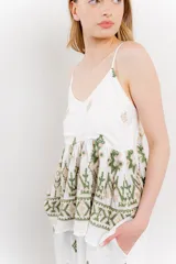 Blusa blanca de algodón con bordados artesanales en verde y corte suelto.