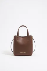 Bolso de piel regenerada color marrón, con estructura rígida y cierre de snap, ideal para uso diario.