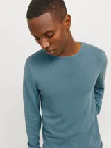 Sweater de punto ligero color azul petróleo, con cuello redondo y mangas largas.