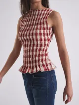 Top sin mangas con cuello redondo y diseño ajustado con frunces elásticos a cuadros rojos y blancos.