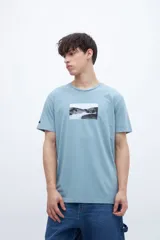 Remera celeste de algodón con cuello redondo y estampado fotográfico rectangular en el centro del pecho.