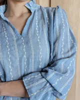 Blusa celeste con cuello mao y mangas abullonadas.