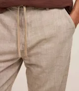 Pantalón relaxed de hombre confeccionado en tejido oxford de algodón color beige, con trabillas en la cintura y cordón para lazo.