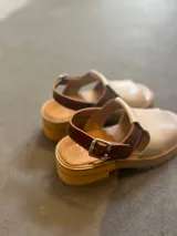 Sandalias de cuero color beige con detalles en marrón, plataforma y tobillera regulable.