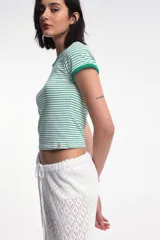 Remera corta de algodón a rayas horizontales blancas y rojas, con cuello y mangas con ribete al tono.