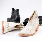Botines de cuero vacuno color blanco con diseño bordado, taco de madera foliado en cuero de 5cm, cierre del lado interior y horma de punta fina.