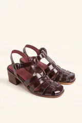 Sandalias de cuero color borgoña con tiras entrecruzadas, hebilla lateral y taco de madera.