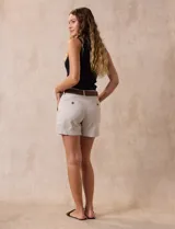 Short de jean azul oscuro con pretina con pasadores, botón y cierre. Delantera con bolsillos. Botón en bolsillos traseros. Incluye cinturón trenzado marrón con hebilla redonda dorada.