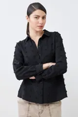 Camisa negra de manga larga con detalle de plumetti.