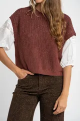 Chaleco de punto color beige con lurex, de corte recto y mangas cortas. Tejido calado con pequeños agujeros.