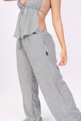 Pantalón palazzo celeste con rayas verticales blancas.