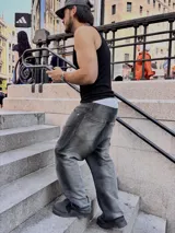 Pantalón de jean gris oscuro con corte amplio y estampado con el logo de la marca en la pierna izquierda.