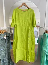 Vestido midi de lino color verde lima, con cuello redondo y mangas cortas con botón. Presenta una hilera de botones en el frente y corte recto.