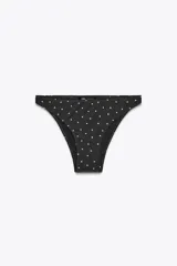 Braguita de bikini negra con lunares blancos, de tiro medio y cintura elástica.