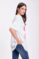 Remera blanca de corte amplio con estampado de copas de martini rosadas con aceitunas verdes.