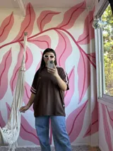 Remerón oversize de algodón color chocolate con mangas cortas y dos tiras rosas en los hombros.