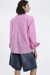 Camisa a rayas verticales rojas y blancas, de corte recto, con cuello clásico, manga larga y bolsillo en el pecho.