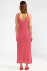 Vestido largo tejido en jersey fucsia, con escote redondo y abertura lateral.