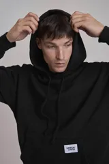 Buzo negro con capucha y bolsillo tipo canguro.