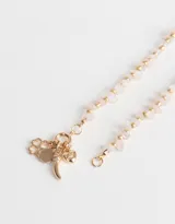 Collar corto dorado con cadena de eslabones, piedras naturales rosas y dijes colgantes dorados.