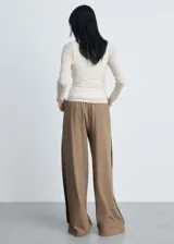 Pantalón wideleg color marrón claro, con cintura elástica, tiro medio, sin cierre, dos bolsillos laterales, estilo jogger y forro interior.