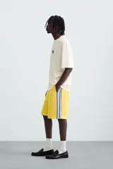 Camiseta blanca de corte holgado, cuello redondo y manga corta. Estampado frontal y trasero con gráficos y textos combinados en color azul.