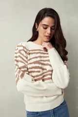Sweater de punto color crudo con estampado animal print en tonos marrones, de mangas abullonadas y puños elastizados.