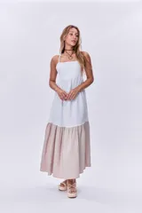 Maxi vestido blanco con corte debajo del busto y falda larga color beige.