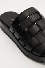 Sandalias bajas color suela, con diseño de tiras anchas entretejidas en el empeine.