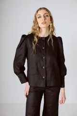 Chaqueta negra de lino con mangas abullonadas y cierre frontal con botones.