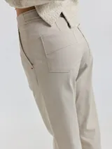 Pantalón de pana color camel, de corte cigarette con detalles de botones en la cintura.