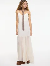 Vestido largo color crema con breteles finos regulables y transparencias en el bajo.