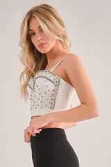 Corset blanco con detalles de pedrería plateada, tiras removibles y espalda ajustable.