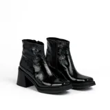 Bota corta de cuero negro, con taco cuadrado y punta cuadrada. Presenta un panel texturizado en el talón y cierre lateral.