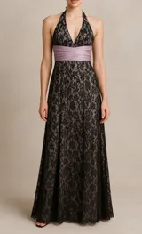 Vestido de fiesta largo de encaje negro con forro nude, escote halter y fajín drapeado color lila.