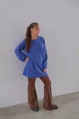 Conjunto de remera color crema de mangas cortas y pantalón acampanado con estampado animal print de leopardo.