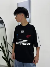 Remera negra de manga corta con cuello redondo y estampado frontal con logo y texto en blanco y rojo.