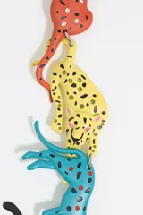 Collar de metal plateado con dijes de panteras de colores: naranja, amarillo, turquesa y negro con lunares blancos.