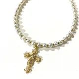 Collar corto de perlas blancas con cuentas doradas y dije de cruz dorada con incrustaciones de perlas y strass.