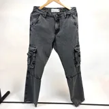 Pantalón jean gris oscuro con efecto lavado, corte holgado, bolsillos laterales tipo cargo con fuelle y doble bolsillo con solapa.