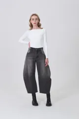 Pantalón de jean gris oscuro, de corte barrel, con bolsillos laterales y traseros, pinzas y tiro medio.